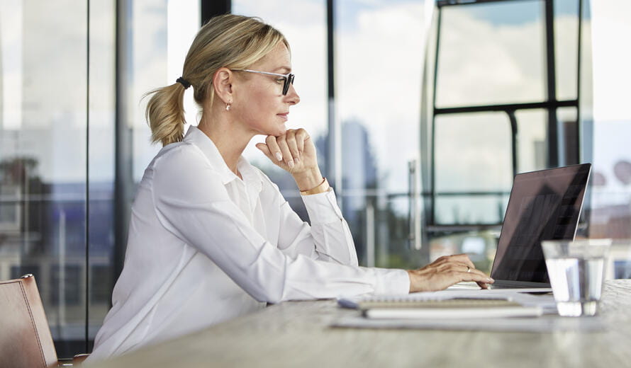 business woman with glasses working on her laptop