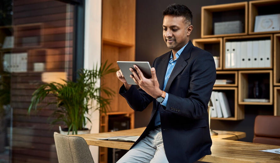 Shot of a confident businessman using a digital tablet in a modern office