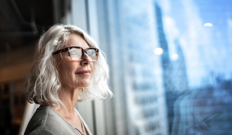 Mature businesswoman looking out of window.