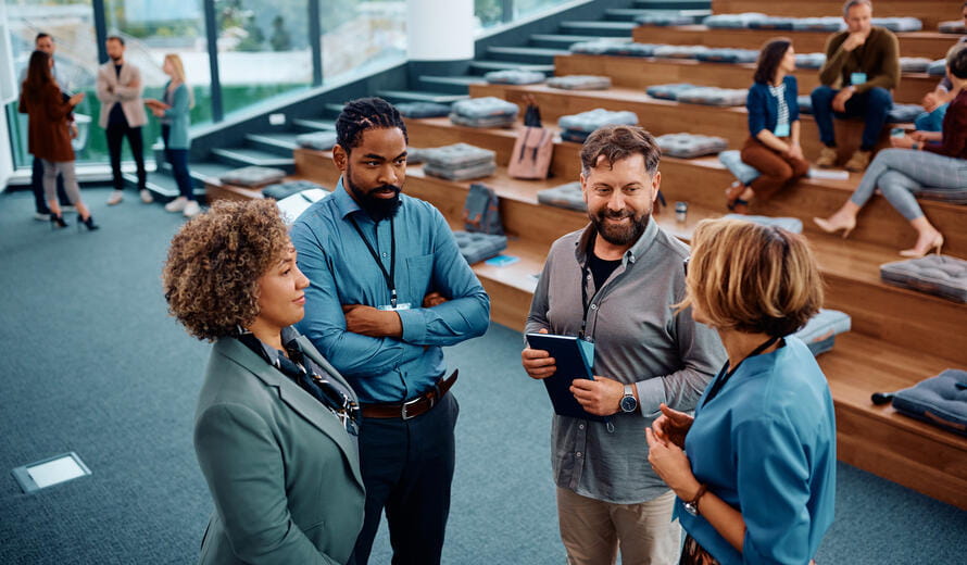 Multiracial group of business people communicating while attending an education event at convention center.